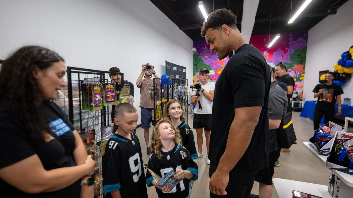 Arik Armstead talks with Hunter Davis, 11, and his sisters Savannah, 6, and Ryan, 9, on Friday at a book signing at Impound Comice in Sacramento. “Discovering My Superpower,” a comic book Armstead created, aims to inspire youth through literacy and empowerment.