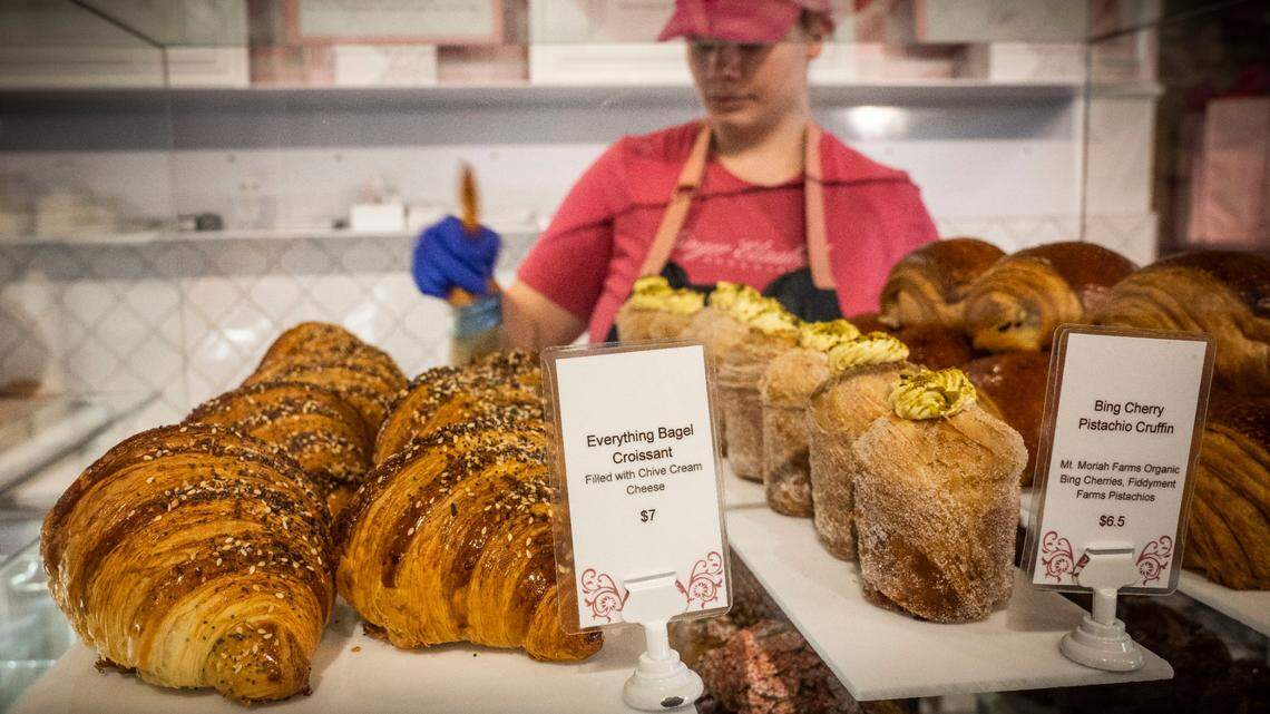 Chloe Cook, an employee at Ginger Elizabeth Patisserie, cleans a pastry rack in 2022. The shop will discontinue most of its baked goods.