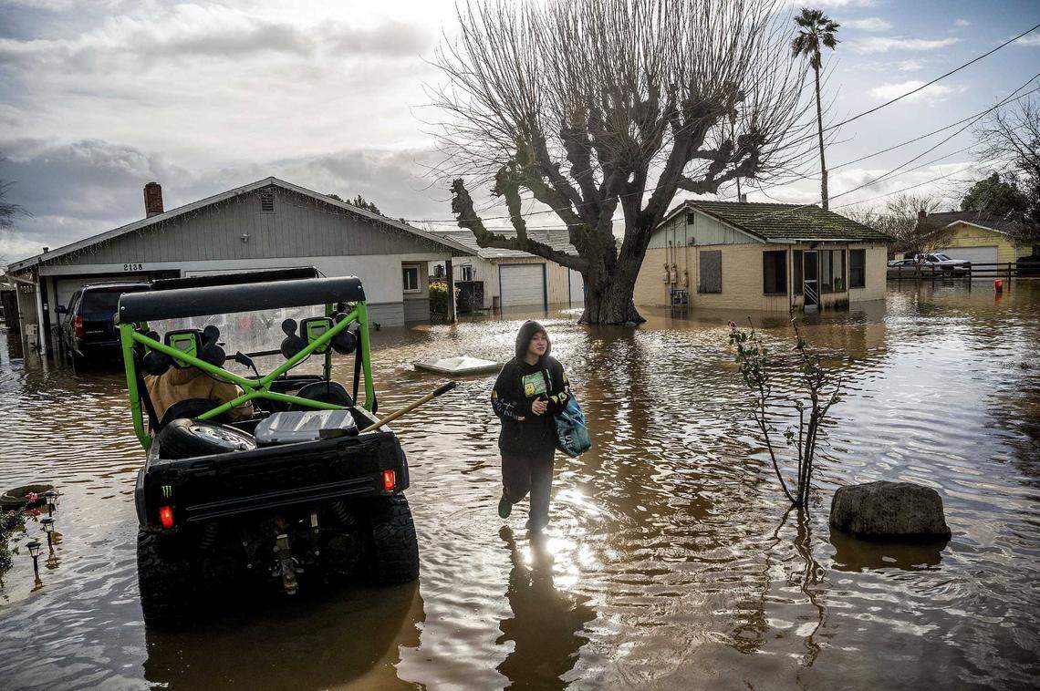 Brenda Ortega, 15, salvages items from her flooded Merced home on Tuesday. Following days of rain, Bear Creek overflowed its banks leaving dozens of homes and vehicles surrounded by floodwaters.