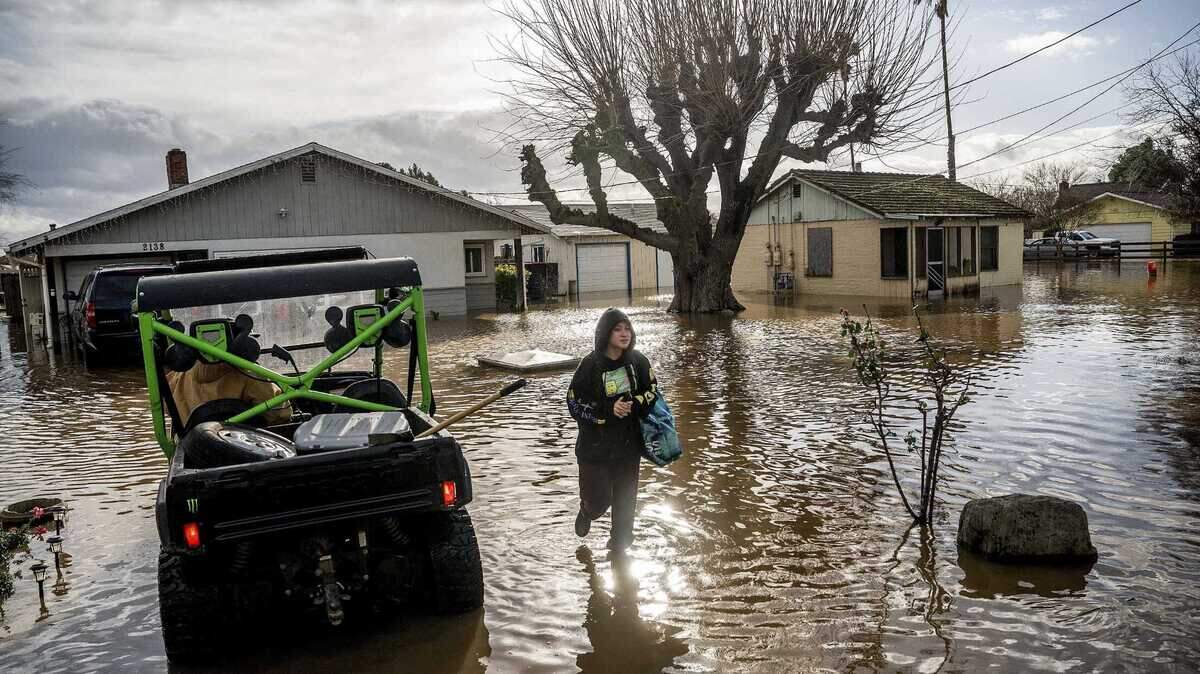 Brenda Ortega, 15, salvages items from her flooded Merced home on Tuesday. Following days of rain, Bear Creek overflowed its banks leaving dozens of homes and vehicles surrounded by floodwaters.