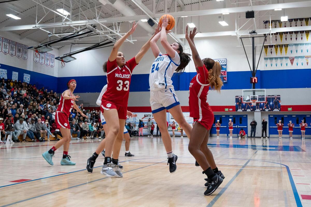 Folsom Bulldogs guard Sophia Mindermann (24) goes up for a shot between McClatchy Lions center Milah Masters (33) and guard Sydney Wilson (2) in the second half of the CIF Sac-Joaquin Section Division I girls semifinal game on Tuesday, Feb. 21, 2023, at Folsom High School. Mindermann had 11 points. The Bulldogs won 57-52.