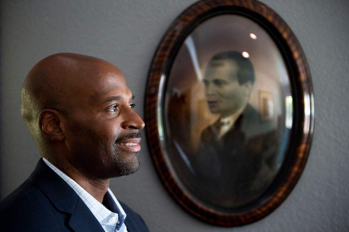 Matt Burgess stands in his Sacrametno home in July near a portrait of his great-great grandfather, Rufus Burgess, who came to Coloma as an enslaved man in the Gold Rush era. He gained his freedom and went on to become a successful entrepreneur.