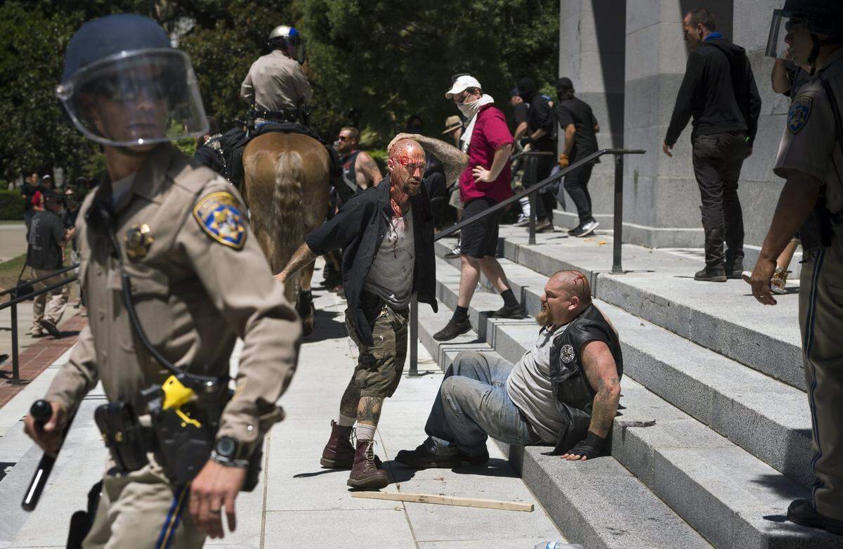 Covered in blood, Jonathan Jordan, left, and Duncan McKenzie, as identified in court documents, wait on the state Capitol steps on Sunday, June 26, 2016, after a violent clash with a Sacramento Antifa group. The two Sacramento residents were part of rally by a white supremacist group called The Traditionalist Worker Party.