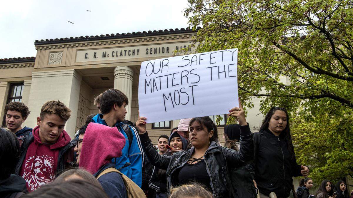 Gloria Razo holds a sign as students walk out in to protest C.K. Mclatchy High School staff's lack of action when it comes to sexual harassment on March 21.