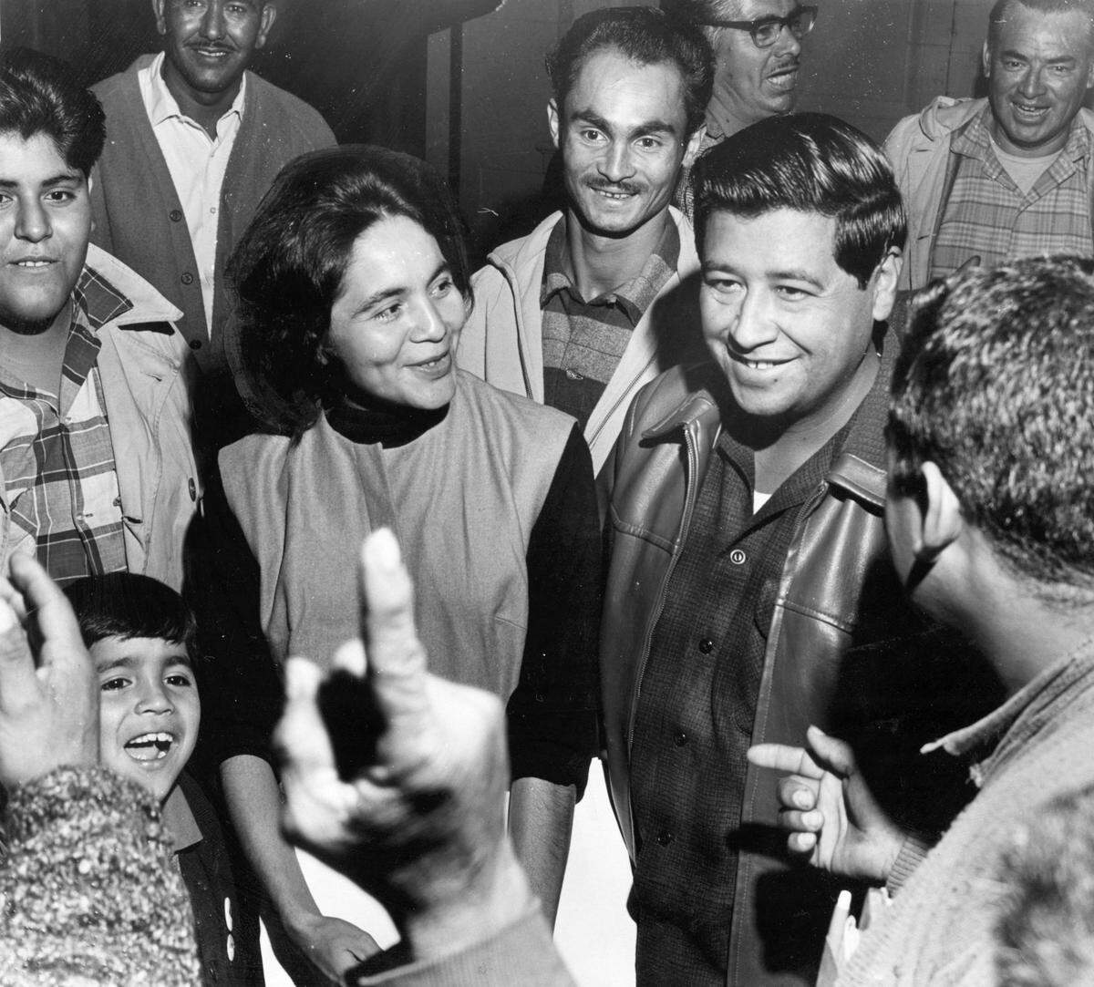 Striking farm workers from the Delano area gather around Dolores Huerta, vice president of the National Farm Workers Association, and Cesar Chavez, the association's general director, before the group asked the executive board of the Community Service Organization to support their strike against grape growers statewide at a meeting at the Hotel Californian in Fresno on Nov. 19, 1965.