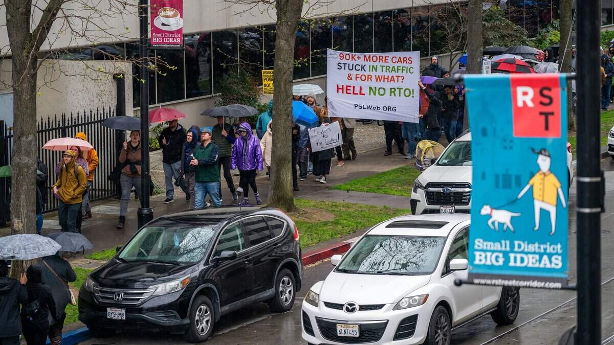 State workers march holding signs around the CalHR offices as they joined hundreds protesting Gavin Newsom’s order directing them to return to their offices four days a week on Wednesday, March 12, 2025, in Sacramento.