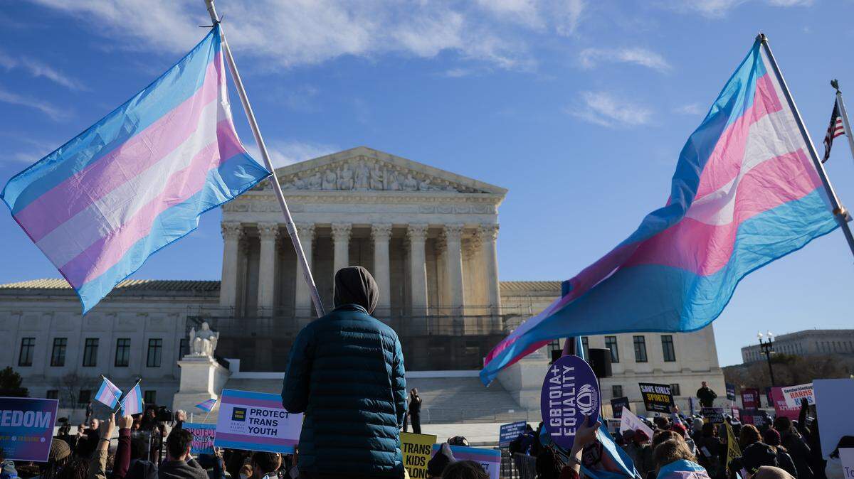 WASHINGTON, DC - JANUARY 13: Protesters supporting transgender athletes competing in women's sports gather outside the Supreme Court on January 13, 2026 in Washington, DC. Groups from both sides of the debate gathered on Tuesday morning to protest while two cases that prohibit transgender girls from joining girls' and women's sports teams are heard inside the Supreme Court. (Photo by Heather Diehl/Getty Images)