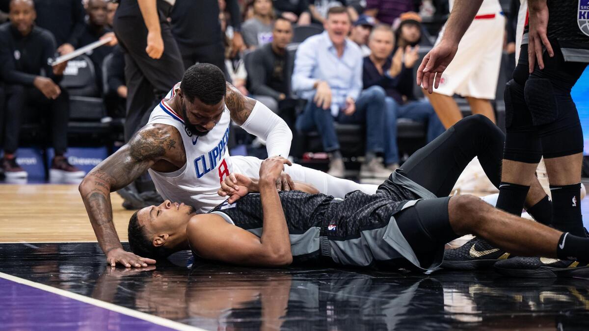 Los Angeles Clippers forward Marcus Morris Sr. (8), top, leans over Sacramento Kings forward Keegan Murray (13), playing his first regular-season NBA game, for a few moments after fouling him during the first half of the basketball game Saturday, Oct. 22, 2022, at Golden 1 Center in Sacramento.
