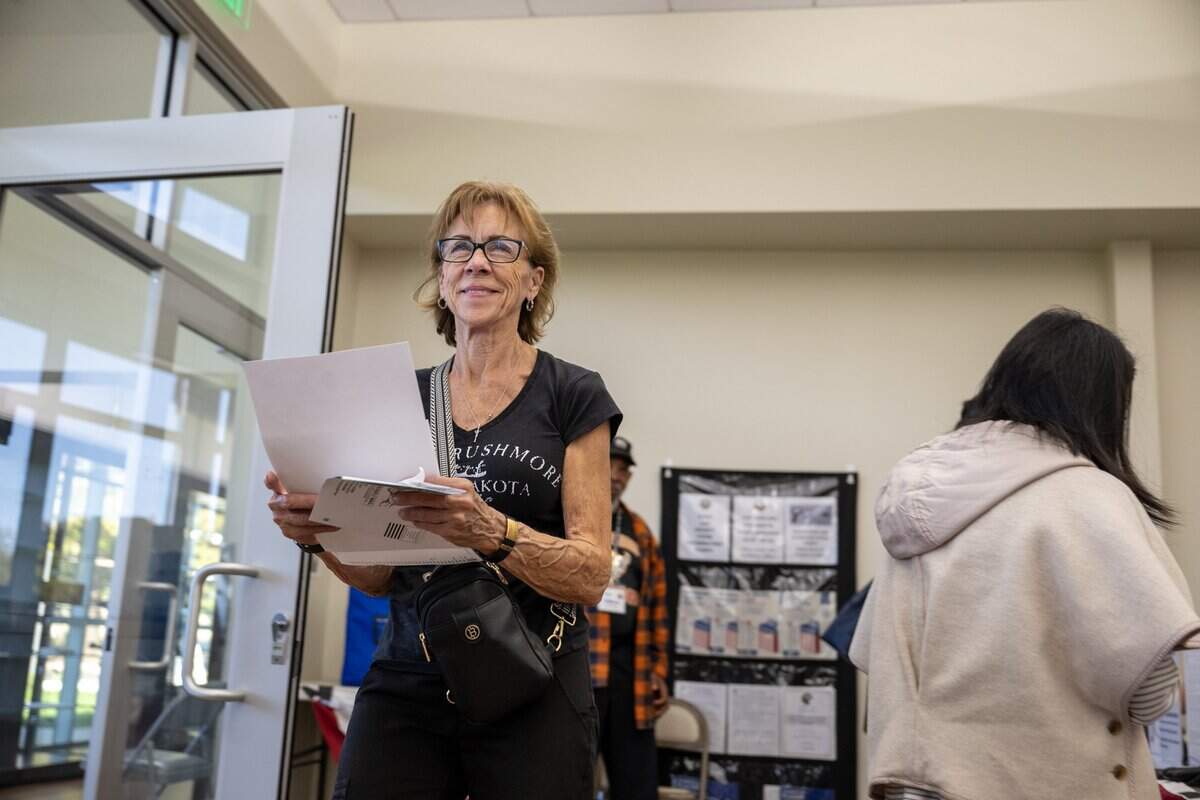 Rebecca Wilson walks toward a voting machine to deposit her ballot at the vote center in the Placer County Clerk-Recorder-Elections Office in Rocklin in 2025.