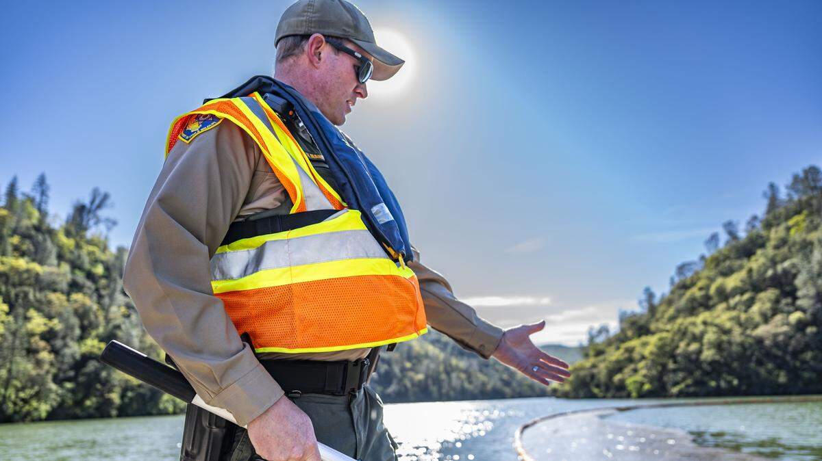 Ryan Hanson, a lieutenant with California Fish and Wildlife, points to a section of wood debris during a tour of Englebright Lake on Tuesday, March 3, 2026. The area was where contaminants were contained following the rupture of a large pipe, called a penstock pipe, at the New Colgate Powerhouse.