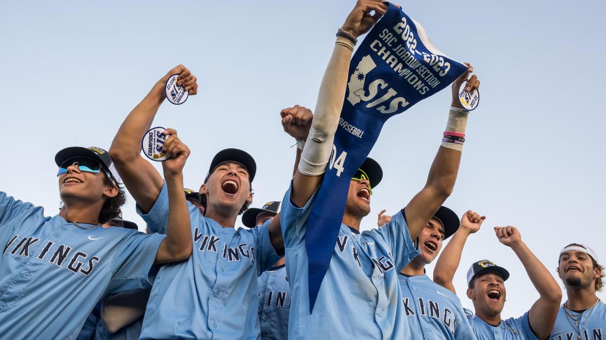 Oakmont Vikings shortstop Adam Reyes (3) is surrounded by teammates as he holds their newly won CIF Sac-Joaquin Section Division IV high school baseball championship banner Wednesday, May 24, 2023, at Sacramento City College. Oakmont beat Woodland, 10-0, after five innings.