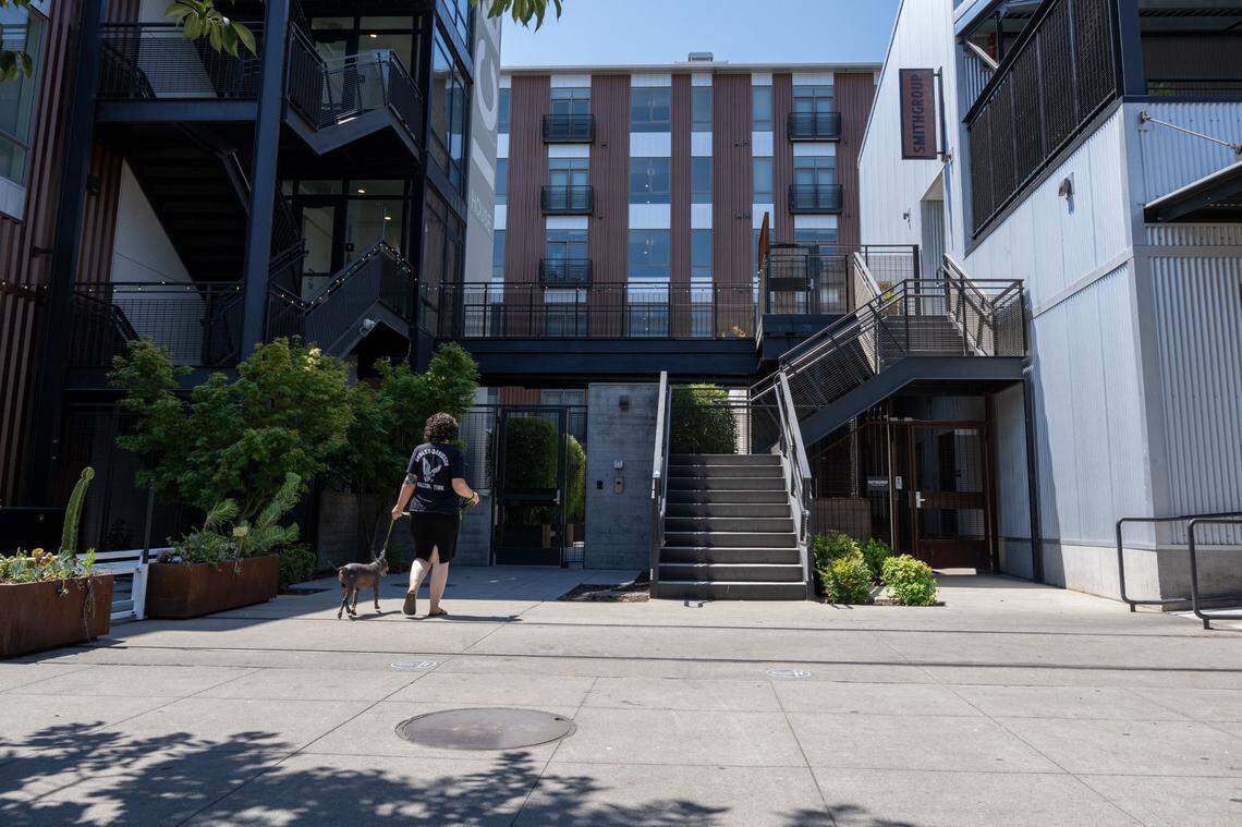 A resident walks to an apartment complex on the R Street corridor on Wednesday, July 19, 2023, lined by hundreds of apartments, high-end restaurants and wide, welcoming sidewalks.