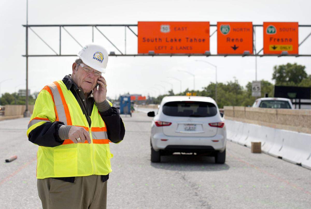 C.C. Myers talks on his phone atop the W-X freeway in Sacramento while construction crews prepared to repave its surface as part of the Fix50 project in 2014. The legendary Sacramento construction icon, who gained fame rebuilding damaged California freeways at breakneck speed, died Wednesday at the age of 85.