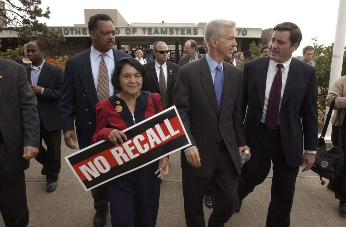 Gov Gray Davis talks with then state insurance commissioner John Garamendi as he leaves a labor rally in Oakland on Oct. 4, 2003 with Rev. Jesse Jackson, left, and Delores Huerta of the United Farm Workers Union. They were at a labor rally at the Teamsters hall for the governor’s “Just Say No" fly around campaign tour against the effort to recall him.