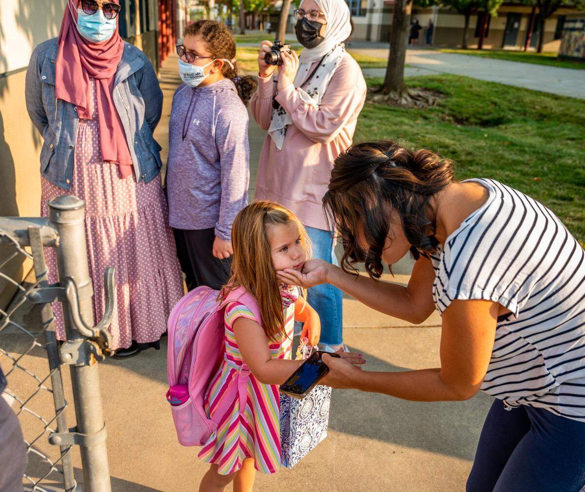 Masako Ciani, right, shares a moment of eye contact with her daughter Audrey, 5, who is in kindergarten, before she starts her first day of school at Empire Oaks Elementary School in Folsom on Aug. 11.