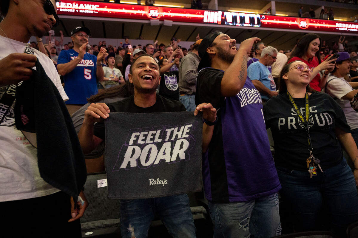 Kings fans Deonte Gregg holds a “Feel the Roar” banner as he celebrates with friends, T Skee, left, and Alex and Ashley Lackey, right, at Golden 1 Center during the Game 6 watch party as the Kings win Friday against the Golden State Warriors in San Francisco.