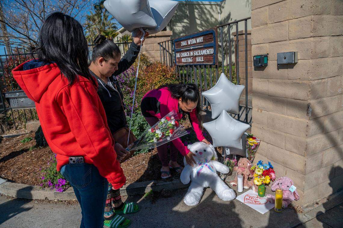 Lizbeth DeJesus, left, Vera Cruz, center, and Ana DeJesus, right, place a large stuffed rabbit, white balloons and flowers at a memorial outside The Church in Sacramento on Wyda Way in Arden Arcade on Tuesday, March 1, 2022. A father killed three of his children and an adult before shooting himself at the church the night before. I left a white bunny there because you feel bad for the girls and the people who knew them, said Lizbeth.