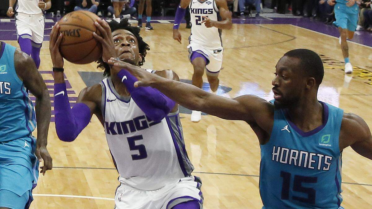Sacramento Kings guard De’Aaron Fox (5) goes to the basket against Charlotte Hornets guard Kemba Walker in the second half Saturday night, Jan. 12, at Golden 1 Center in Sacramento.