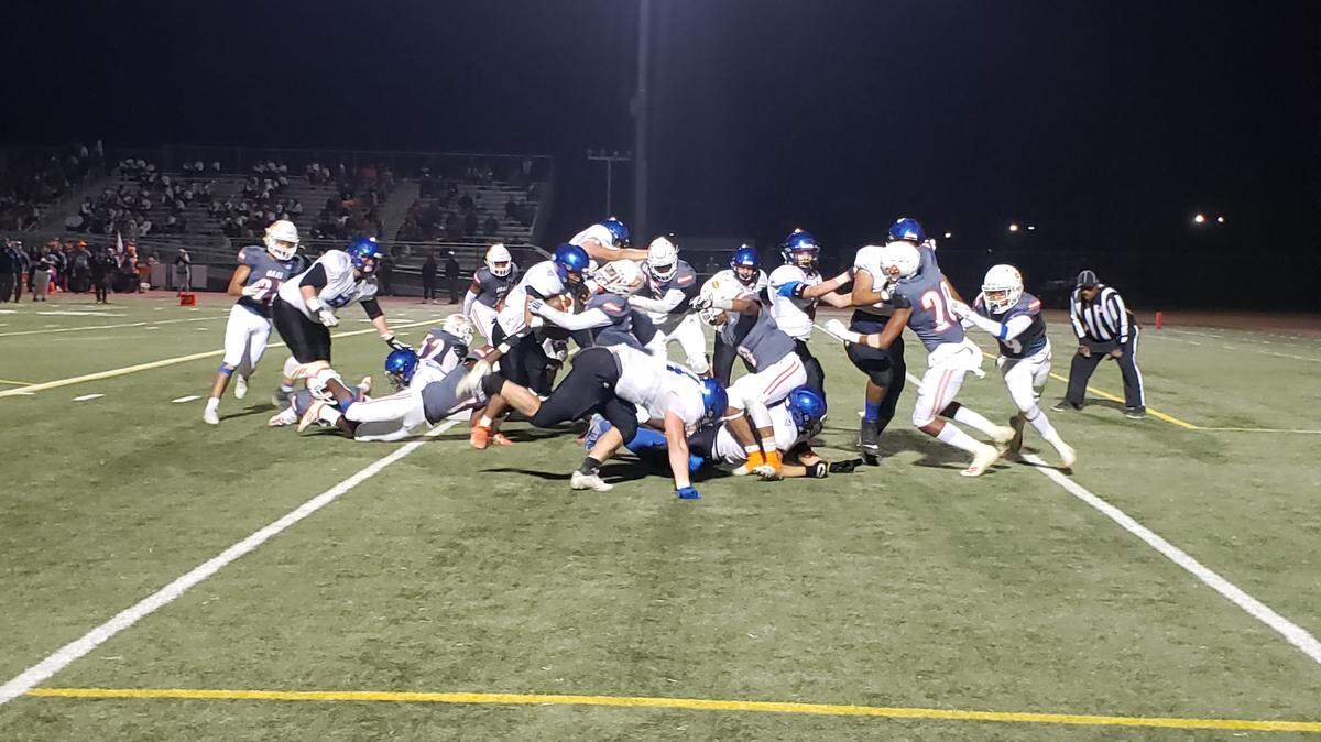 The Davis offensive line clears the way for running back Taylor Vaughn near the end zone Friday against Cosumnes Oaks.