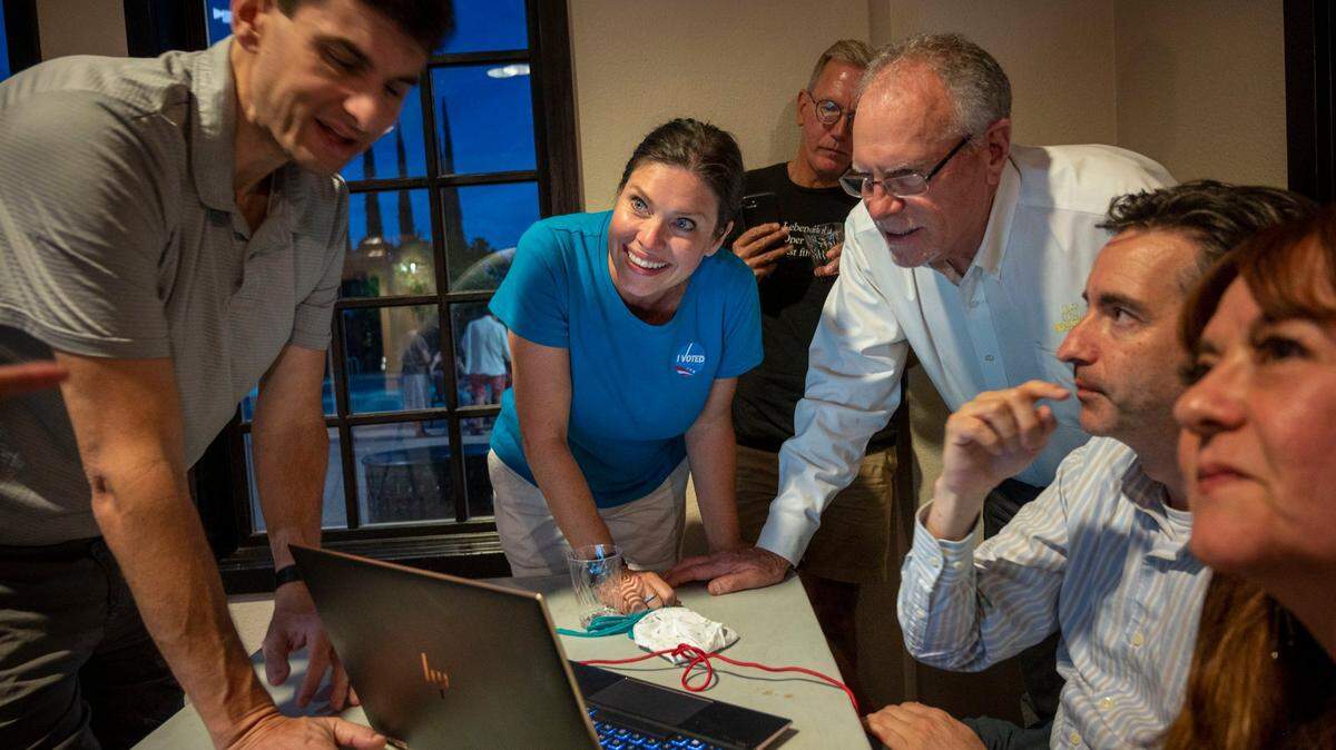 Sacramento City Council candidate Lisa Kaplan, center, stands with campaign supporters as they look at early results during her election watch party in North Natomas on Tuessday, June 7, 2022.
