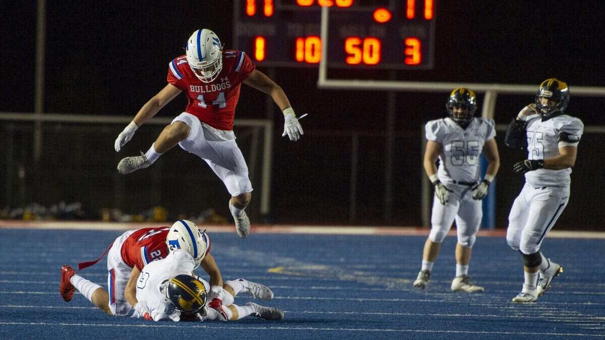 Folsom linebacker Josh Tremain jumps over a tackle by Victor Flores on Oak Ridge WR Brandon Barthel on March 13 at Folsom High School.