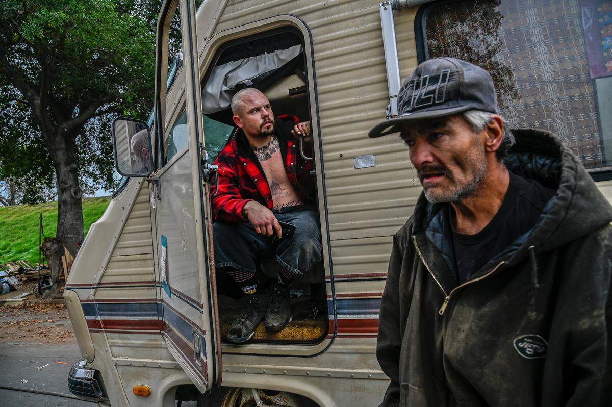 Dan Uyeda, right, was helping friends move including Shawn Stanner, left, as city crews clear vehicles and trailers along Lathrop Way on Monday, Dec. 6, 2021. “We are doing everything we can to just save his home,” said Uyeda.