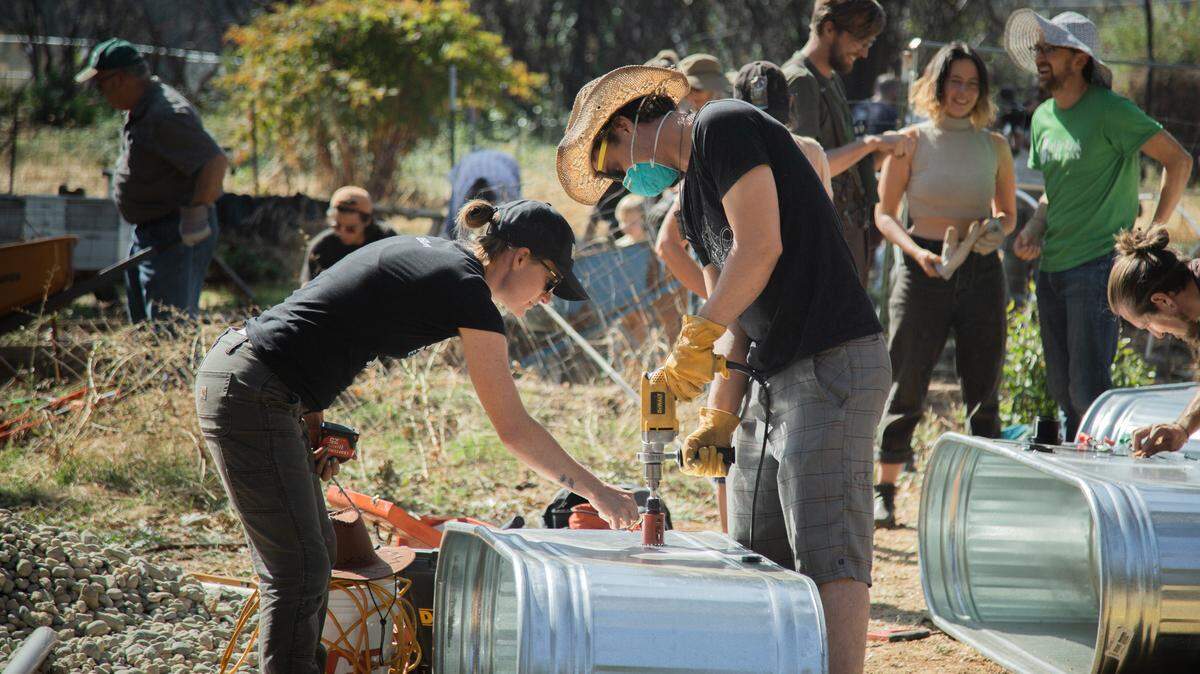 Restoration volunteers build wicking beds – self-contained raised beds with built-in reservoirs that supply water from the bottom up.
