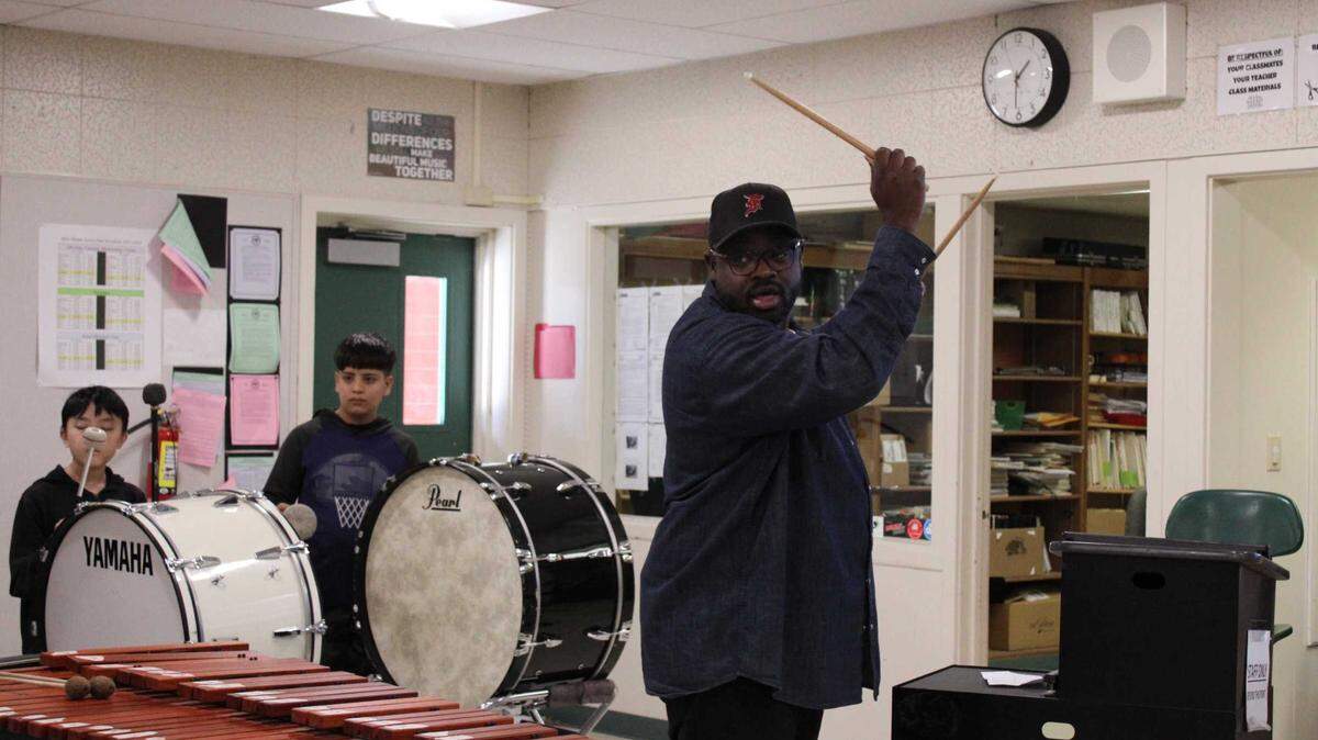 Mills Middle School music instructor Jimmie Adams reviews a cadence as drum line students, from left to right, Chad Xiong and Mohammad Rehan Jalali watch on Wednesday, Dec. 7, 2022. It’s the first year Mills Middle School has offered drum line to students.