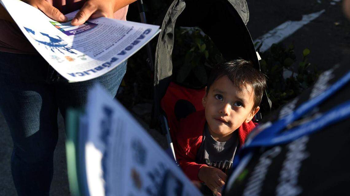 Matias Sanchez watches Juana Dominguez hand out information about Medi-Cal along Main St. in Los Angeles, in 2023. Sacramento will face financial challenges to maintain the existing program in the next budget. (Wally Skalij/Los Angeles Times/TNS)