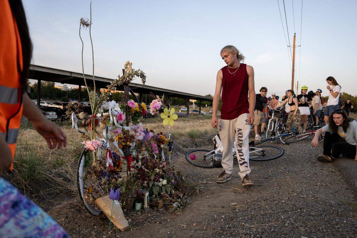 Singer Soules walks Wednesday past the ghost bike memorial on Hutchison Drive for Lincoln Sabini, a UC Davis student who was killed in a crash while cycling.