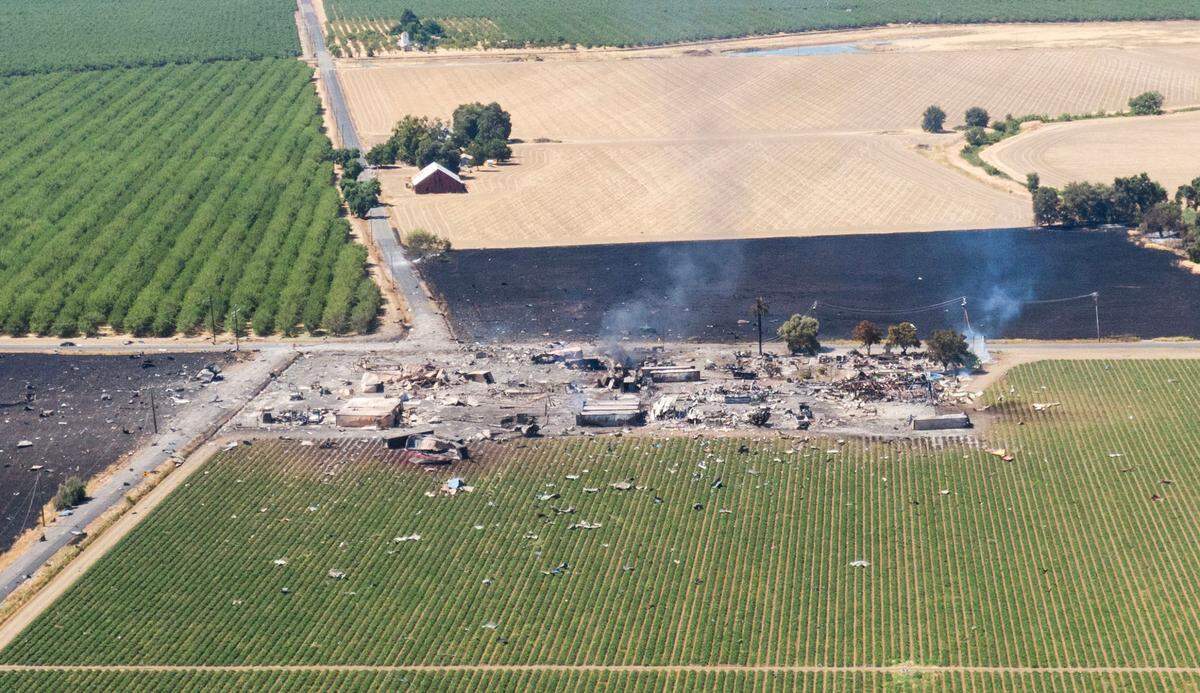 The fields surrounding a fireworks facility are littered with debris on Wednesday, the day after an explosion leveled the site near Esparto in Yolo County.