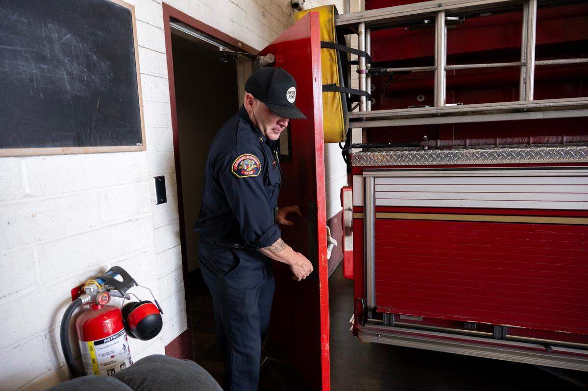Sacramento Metropolitan Fire Battalion Chief Parker Wilbourn, a spokesman for the district, demonstrates the cramped space between a door and a fire engine at Station 41, built in the 1950s, in North Highlands earlier this month.