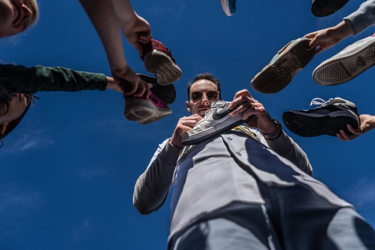 Athletics slugger Brent Rooker signs autographs on shoes as he and some of his teammates visit Mariemont Elementary School in Arden Arcade on Tuesday, Jan. 7, 2025.