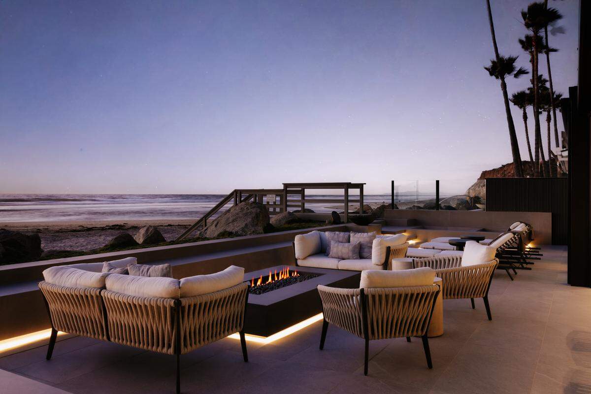 A sprawling oceanfront deck stretches the width of the estate, complete with outdoor kitchen, heaters, fire pit and retractable shades.
