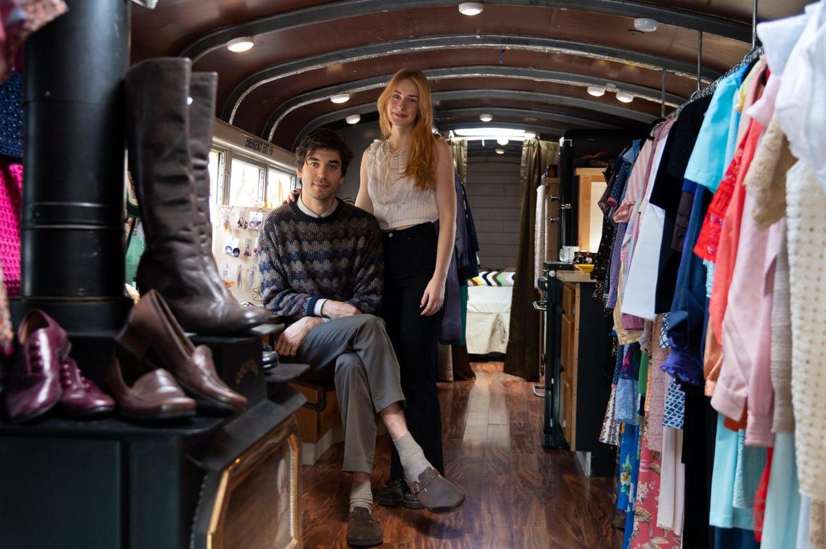 Audrey Panson and Alika Lemon are surrounded on March 4 by clothing for sale inside of the bus.