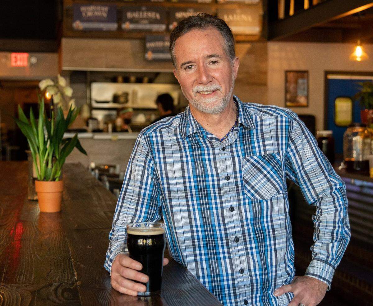Ray Ballestero holds a nitro stout at Alaro Craft Brewery in midtown Sacramento on Friday, Oct. 15, 2021. When the nitrogenated beer is poured, its color changes from medium brown to black as the bubbles surface. “It’s beautiful to look at,” he said.