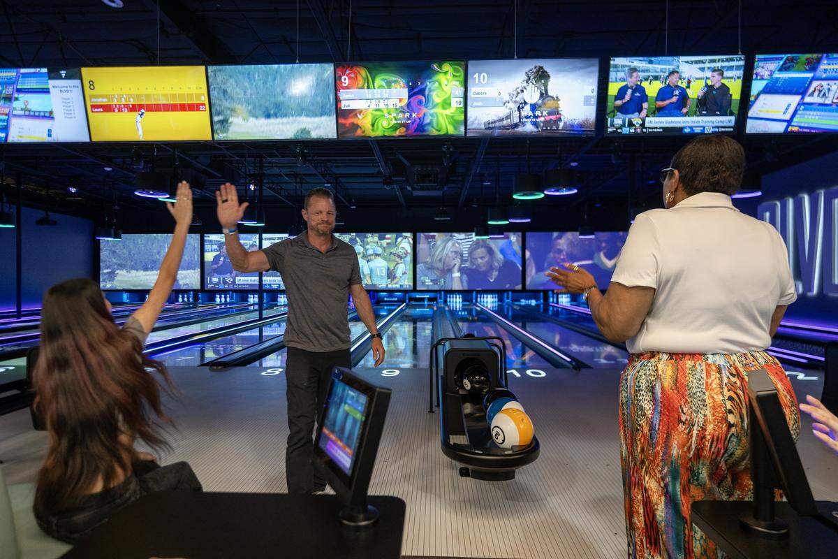 Aaron Provencal high fives Juli Maurizio after bowling a frame at the bowling center at the BLVD in West Sacramento on Wednesday, Aug. 6, 2025.