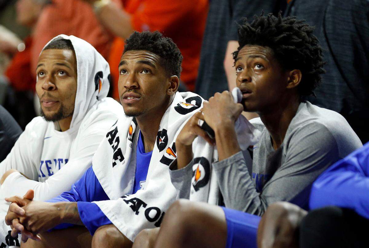 Kentucky Wildcats guards Malik Monk, center, and De’Aaron Fox, right, watch the last few minutes of a game against the University of Florida in Gainesville, in 2017.