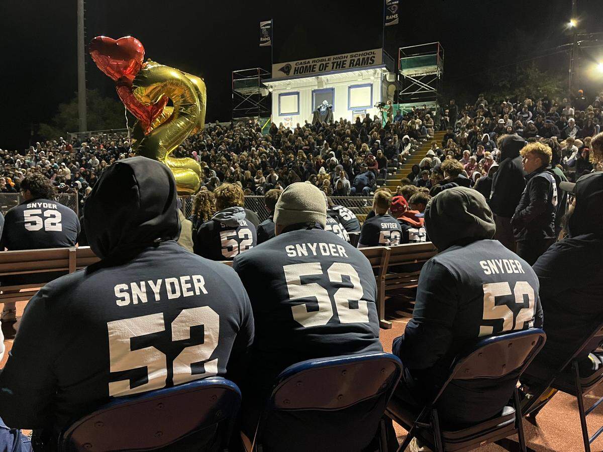 Loved ones and community members gather at Casa Roble High School in Orangevale for a vigil for senior football player Julian Snyder, who died Friday in a vehicle crash in Roseville.