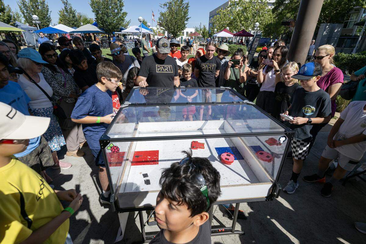 Robotics fans look on as contestants battle it out at the Summer Smash combat robotics event Saturday at Vernon Square in Roseville. 