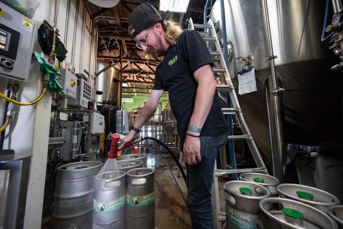 Jonathan Tate with King Cong Brewing Company washes beer tanks last month in Del Paso Heights.