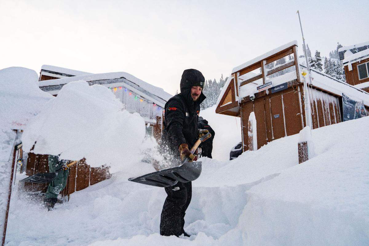 A staff member at Palisades Tahoe shovels snow the morning of March 13, 2025, after an overnight snowstorm brought more than 2 feet of new powder to the resort.