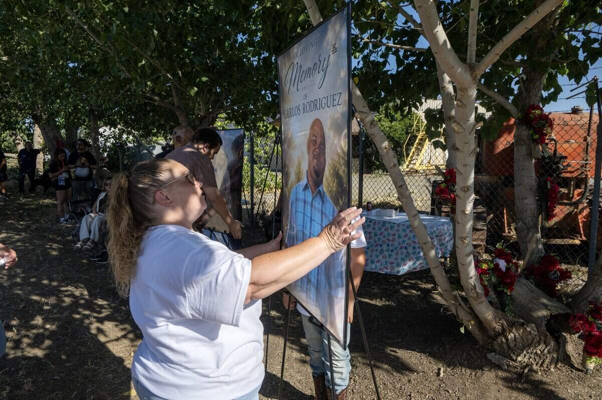 Tiffany Nolan-Rodriguez holds a photograph of her late husband Carlos at a vigil on Wednesday for the seven men who died in the fireworks explosion in Esparto on the first anniversary of the event.