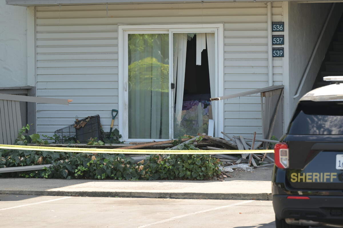 A sliding door and fencing are damaged outside the Arden Arcade apartment where three people were found dead on Friday following reports of a shooting suspect being holed up inside.