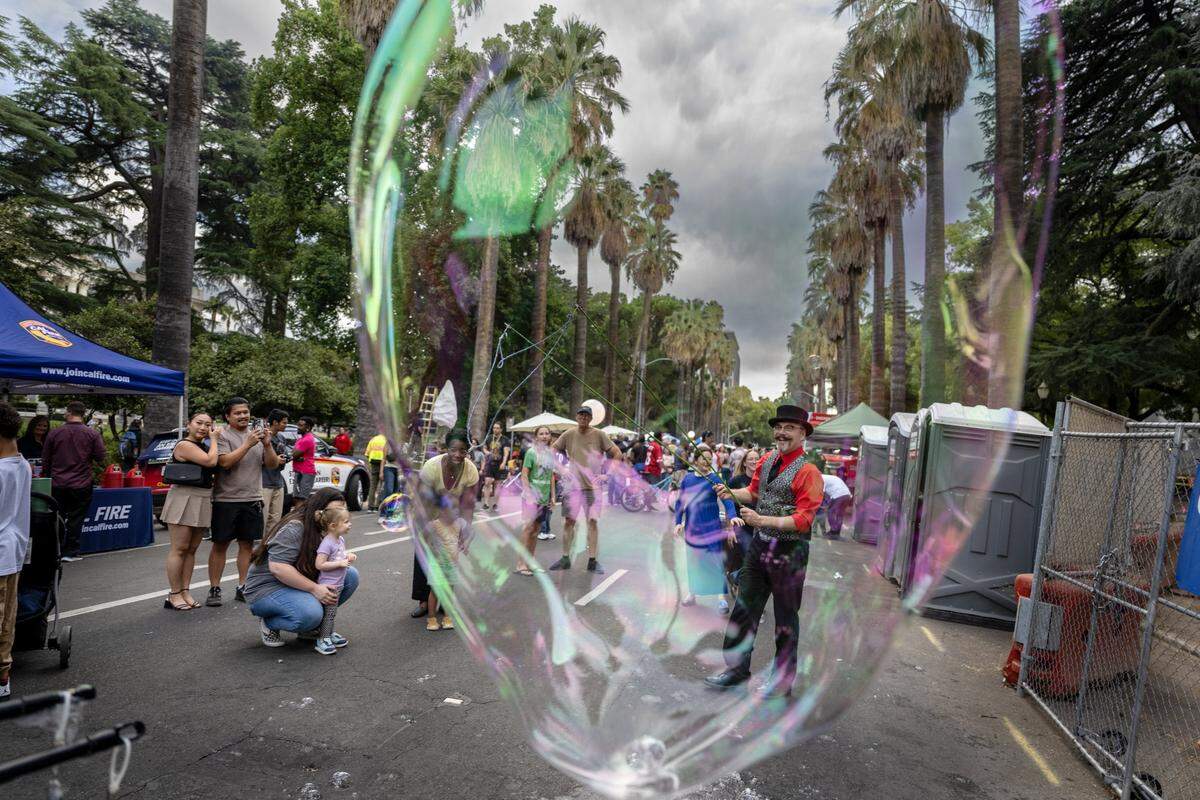 Visitors admire bubbles created by Shane Romick of the Aries Moon Circus during a 175th birthday block party to celebrate California's anniversary of statehood on Tuesday, Sept. 9, 2025, at the state Capitol.