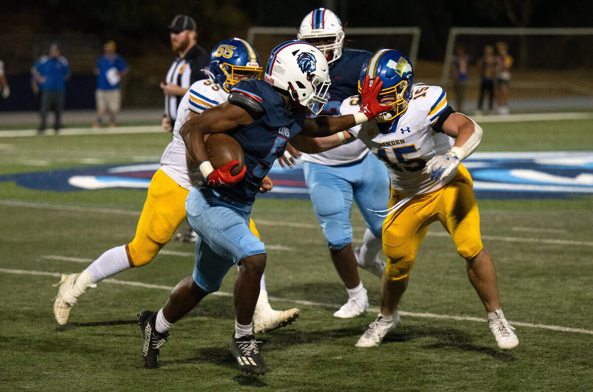 The Destiny Christian Lions’ Malakai Taione (5) stiff arms The Linden Lions’ Braden Busalacchi (15) on the way to a long gain on Friday in Rosemont.