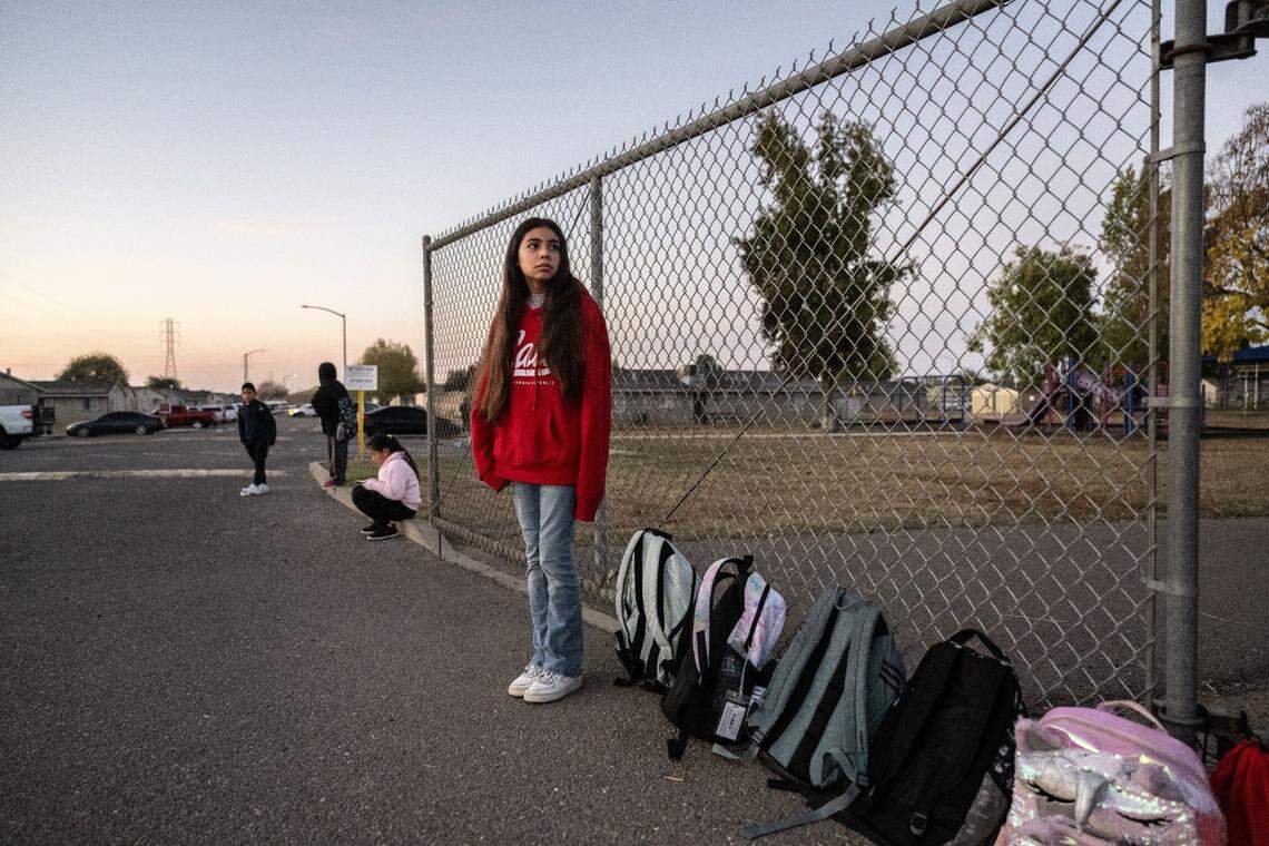Karla Acevedo Perez, 11, waits for the school bus at the Lodi migrant center in October. Karla will have to leave her school when she returns to Mexico after the center closes for the winter.
