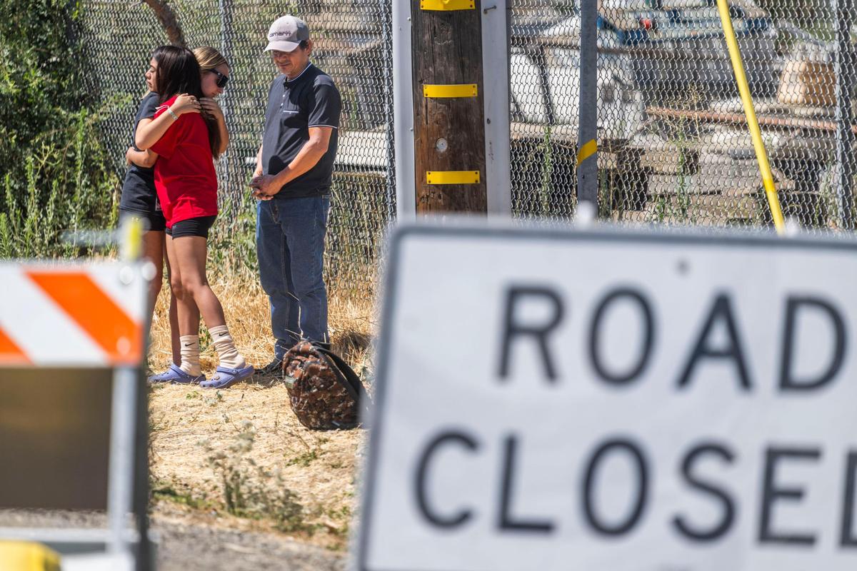 Jhony Ramos, father of fireworks warehouse explosion victims Jhony Ramos Jr. and Jesus Ramos, waits near a road block after a press conference on Monday. Ramos said he was not allowed to go to the press conference and ask questions about his missing sons.