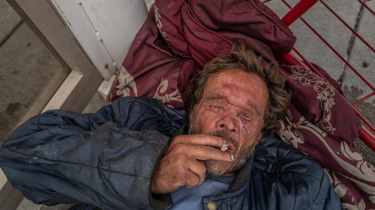Mark Rippee, 59, rests on the side of a bus stop after urinating outside in Vacaville, Monday, Aug. 1, 2022. “I would like to see my brother receive treatment for the no fault brain disease that he has. I would like to see him have safe housing. He just needs someone to care for him,” said his sister Linda Privatte.
