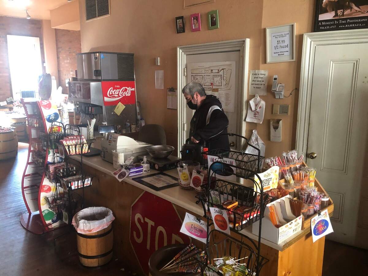 Phillip Perez, manager at Munchies candy shop in Old Sacramento, used a generator to power his scale and cash register on Wednesday, Dec. 15 and Thursday, Dec. 16, 2021, the second and third days of a widespread power outage in Old Sacramento due to a SMUD substation fire.
